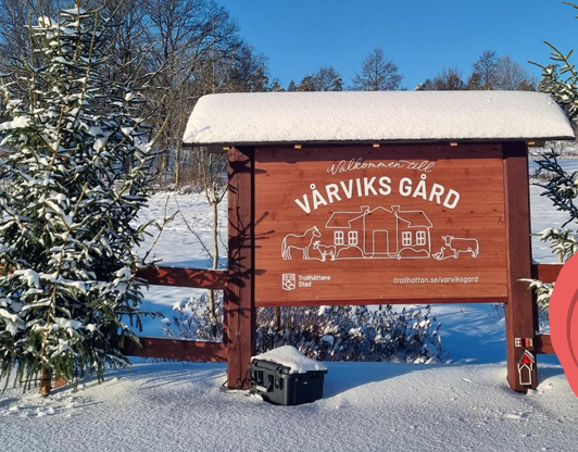 Skylt för Vårviks Gård med snö runtomkring