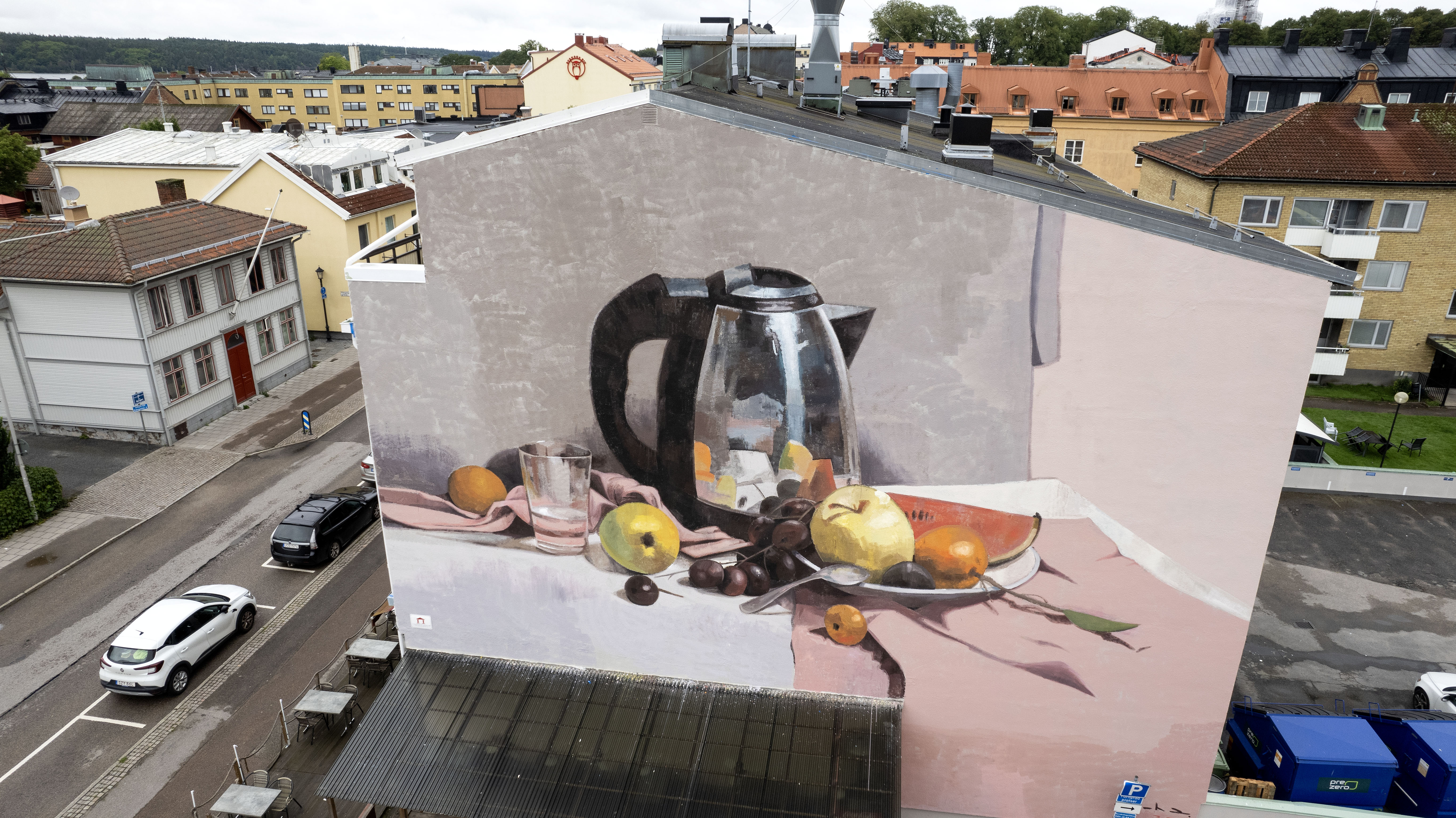 Väggmålning på vattenkokare och frukter på bord 