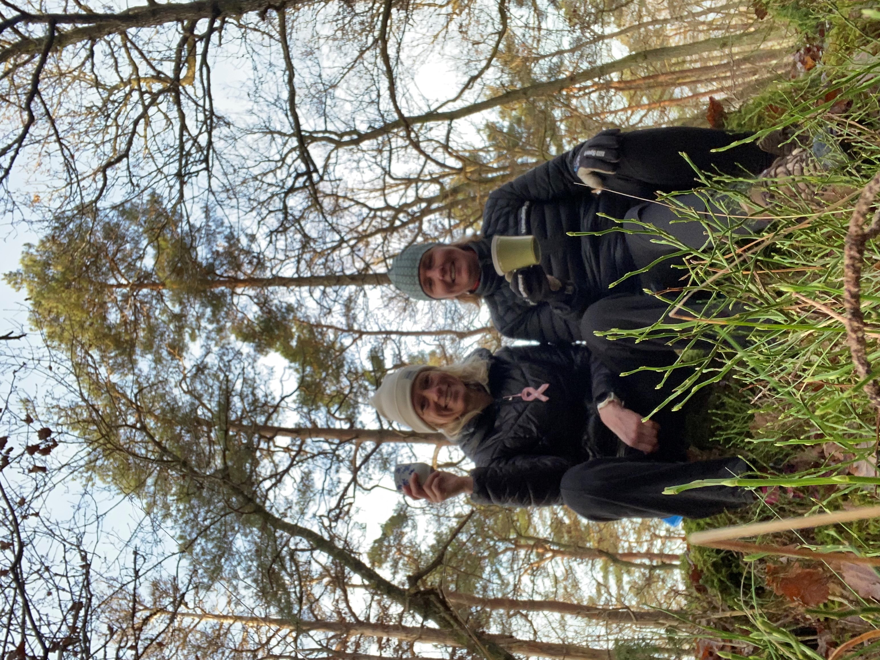 Två kvinnor i naturen med varsin kopp