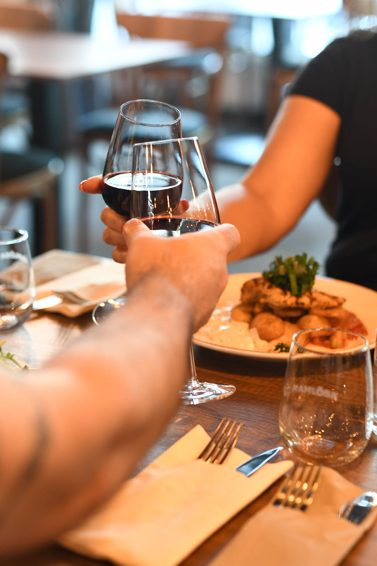 Two hands holding wineglasses