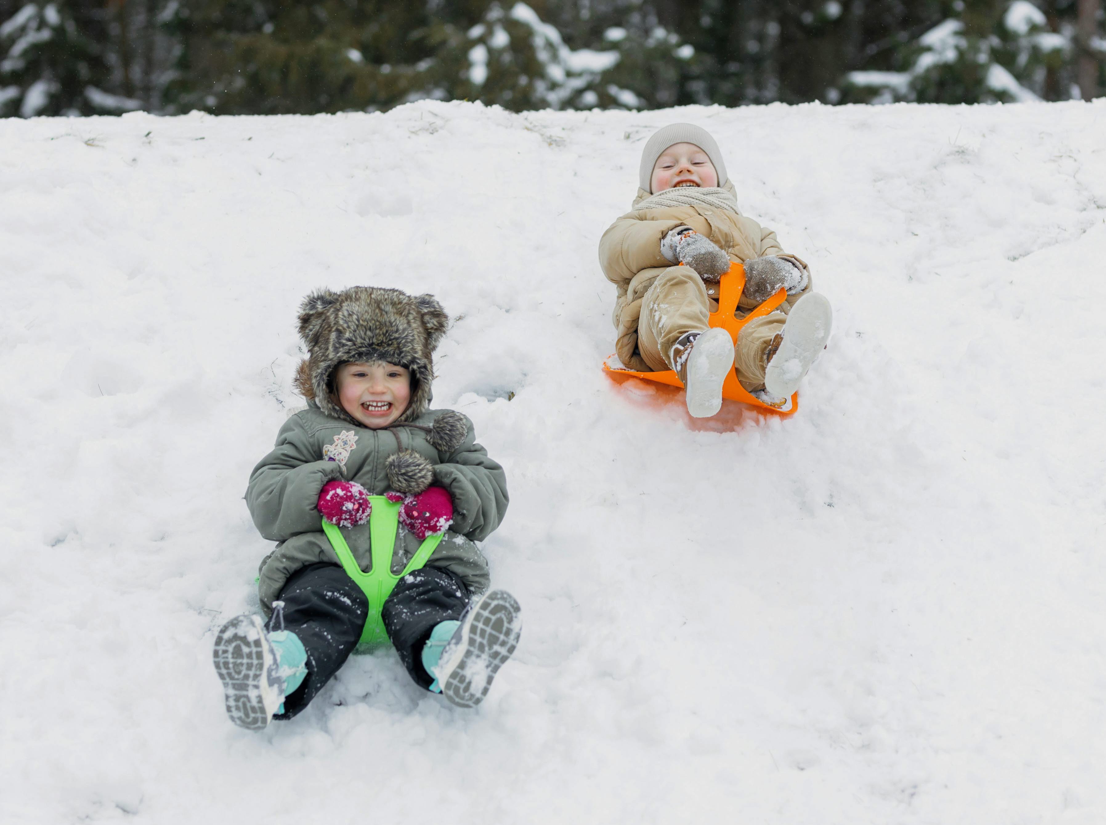 Två barn som åker pulka