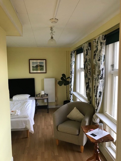 hotellrum med säng, fåtölj, bord