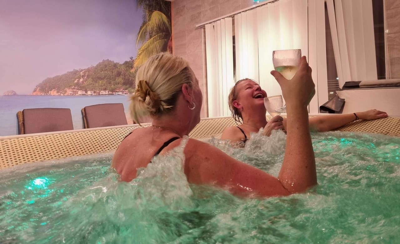 två kvinnor skålar i jacuzzin på spa