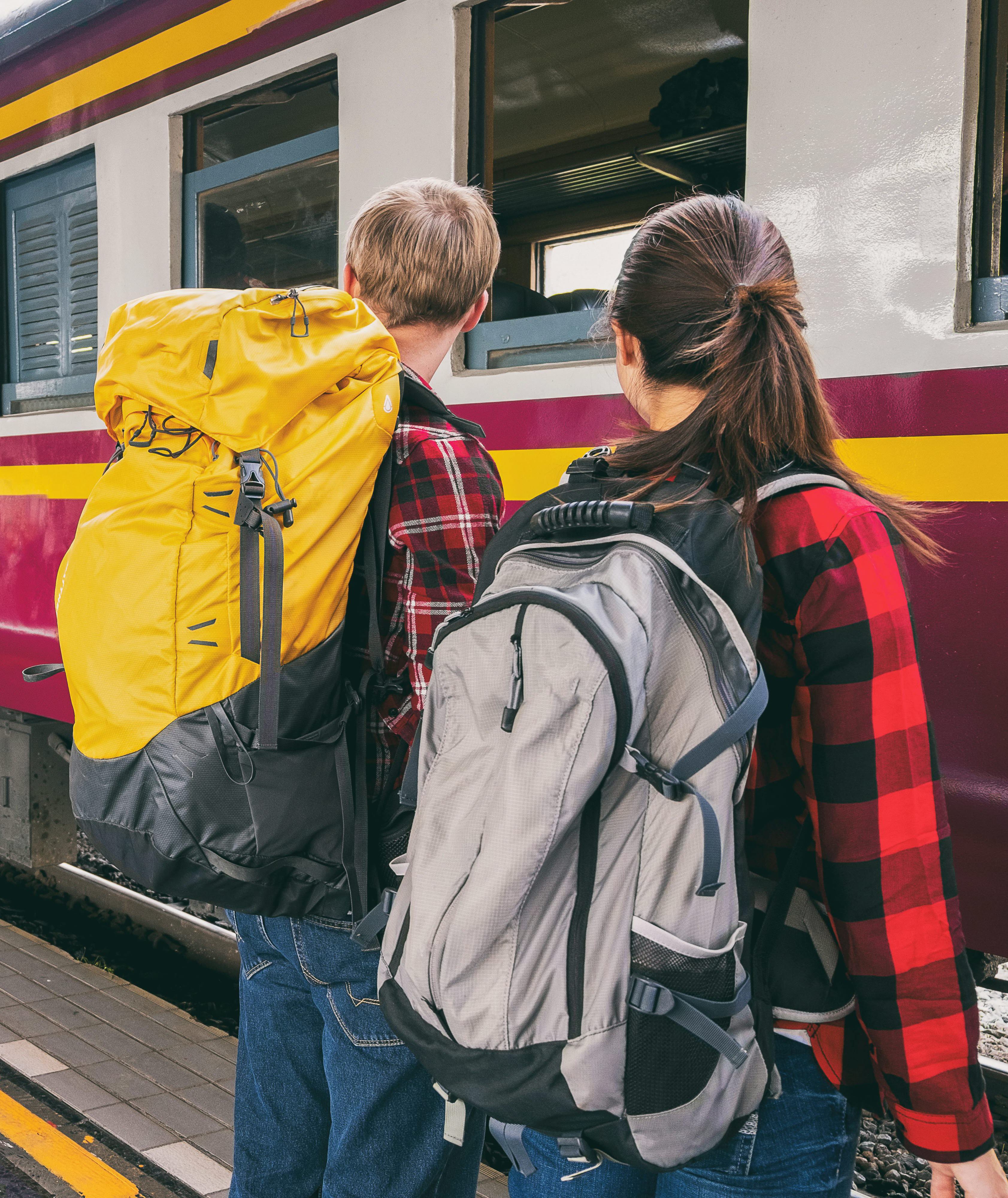 Två personer som ska kliva ombord på ett tåg