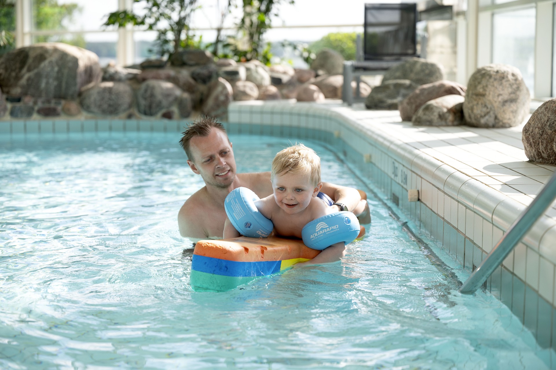 Pappa och son som badar i pool 