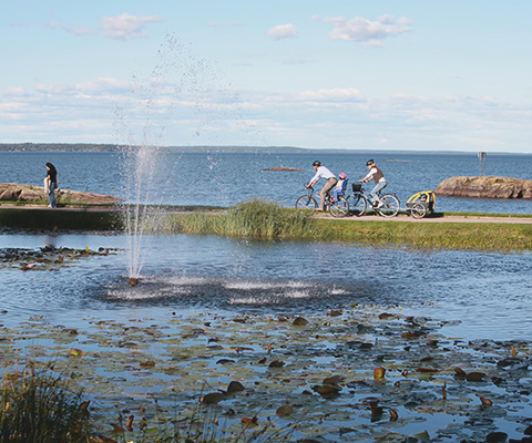 Two people bilking along the shore of Lake Vänern.
