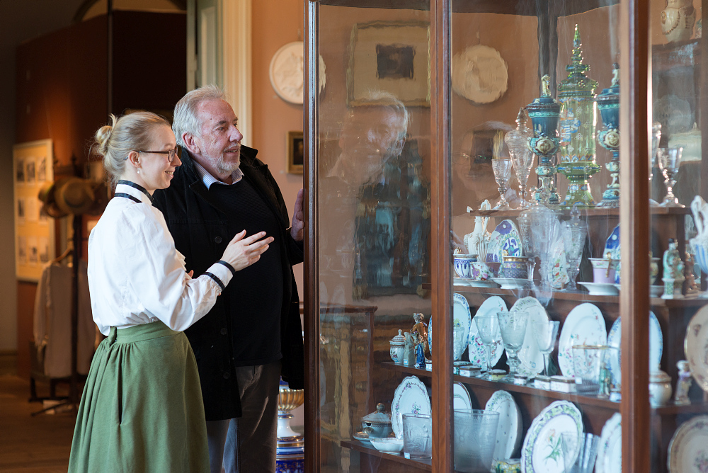 Guide som visar porslin för besökare