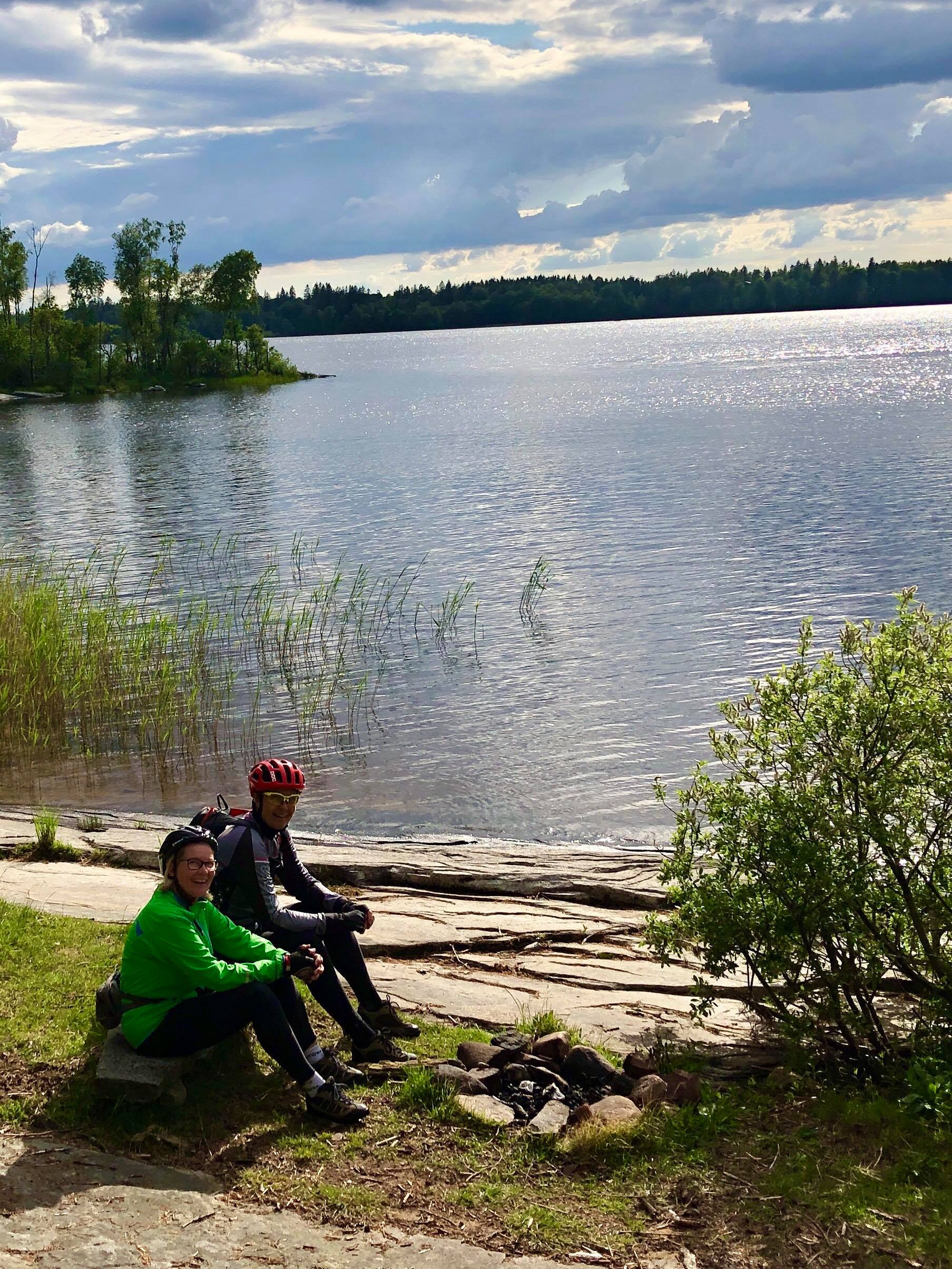 Two persons resting near a lake