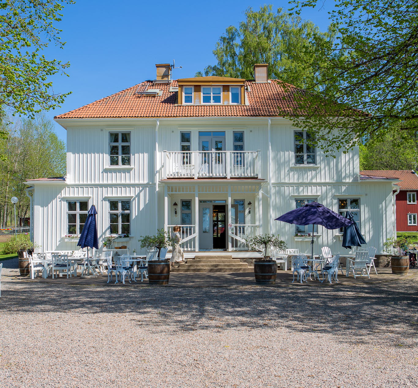 Framsidan av en vit herrgård med rött tak