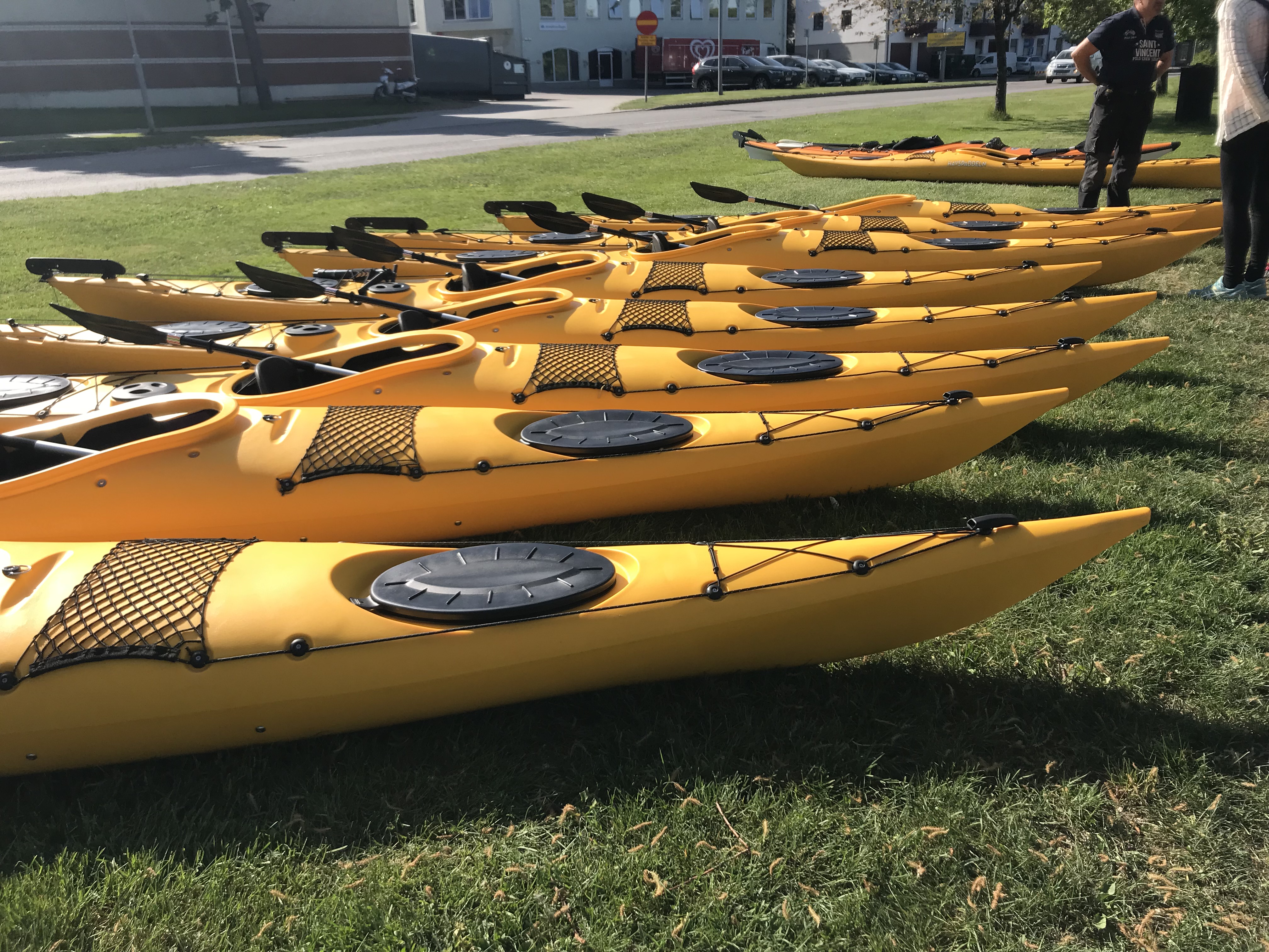 Männsikor i och runt Gula kanoter på en blå sjö i Ulricehamn