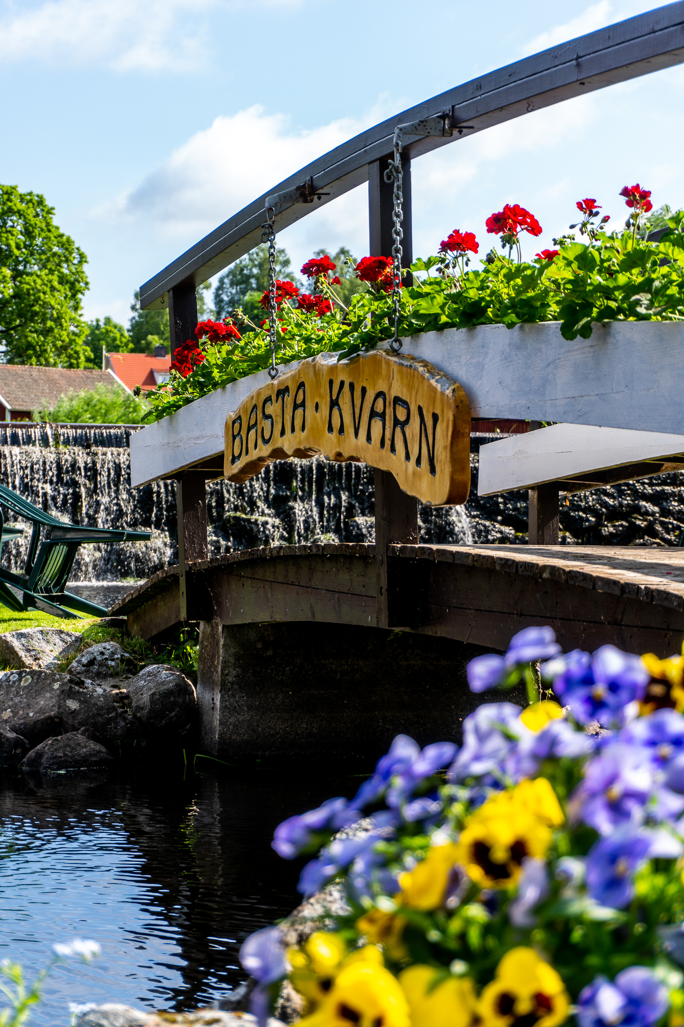 Bild på en bro vid ett kafé. Bron går ut till en liten ö i en å.