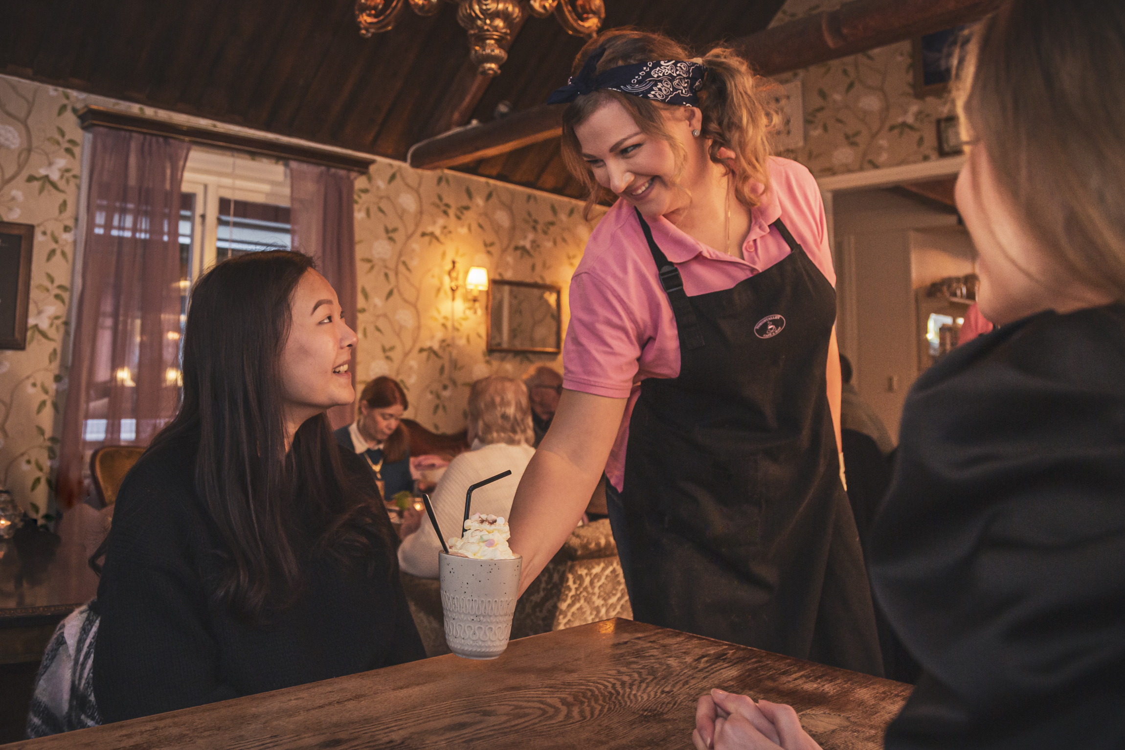 Tjej servererar två gäster fika