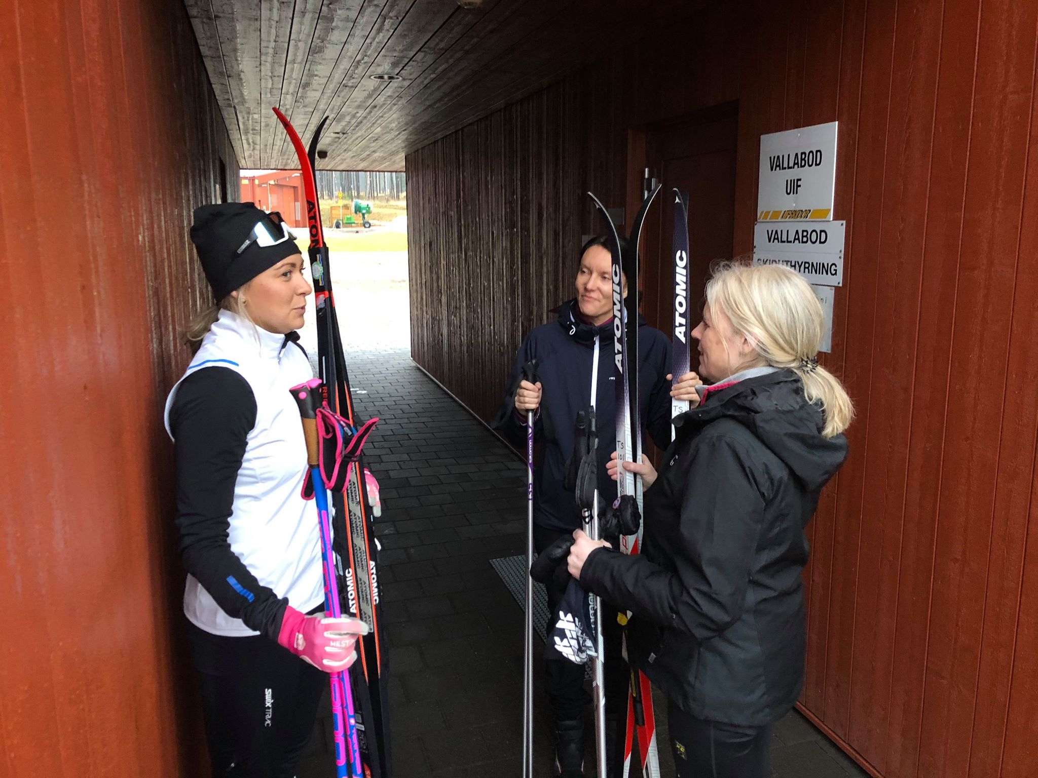Längdskidåkningstjejer står och talar med varandra