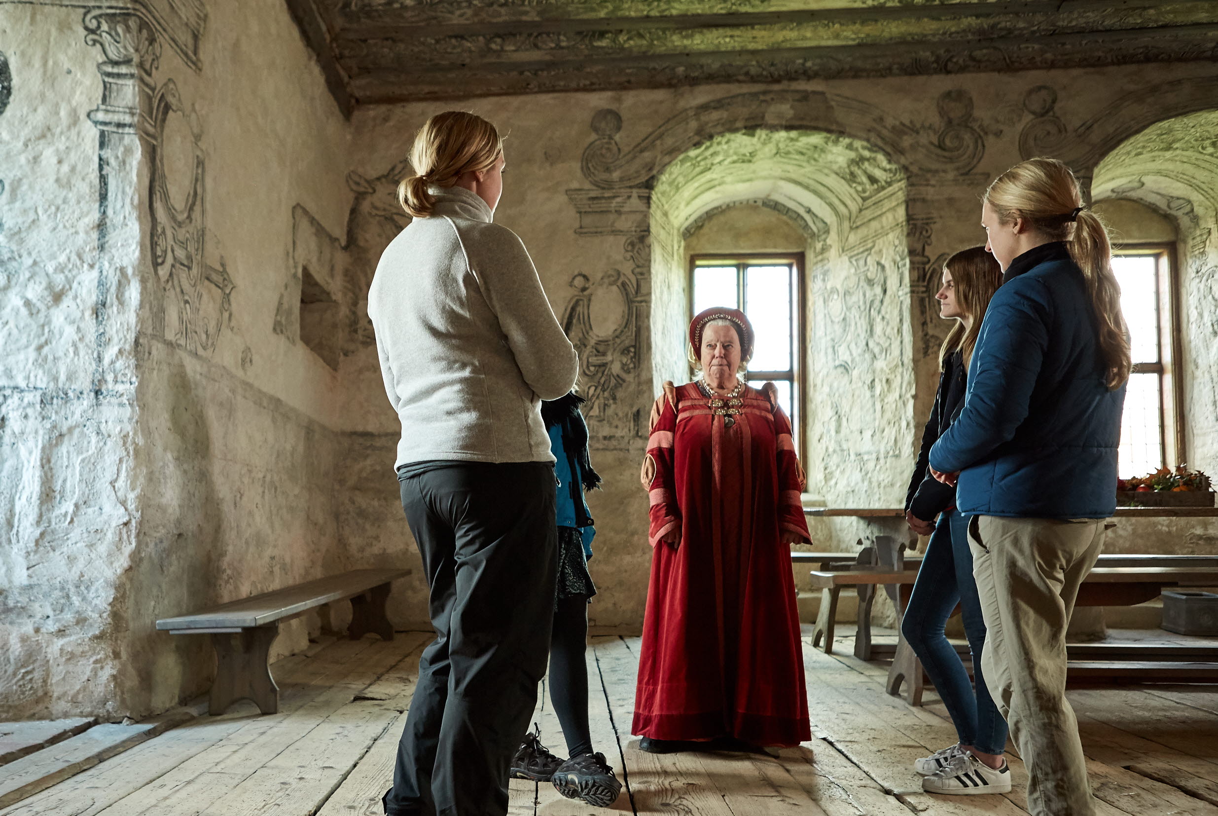 Guide talar med grupp inne på Torpa Stenhus