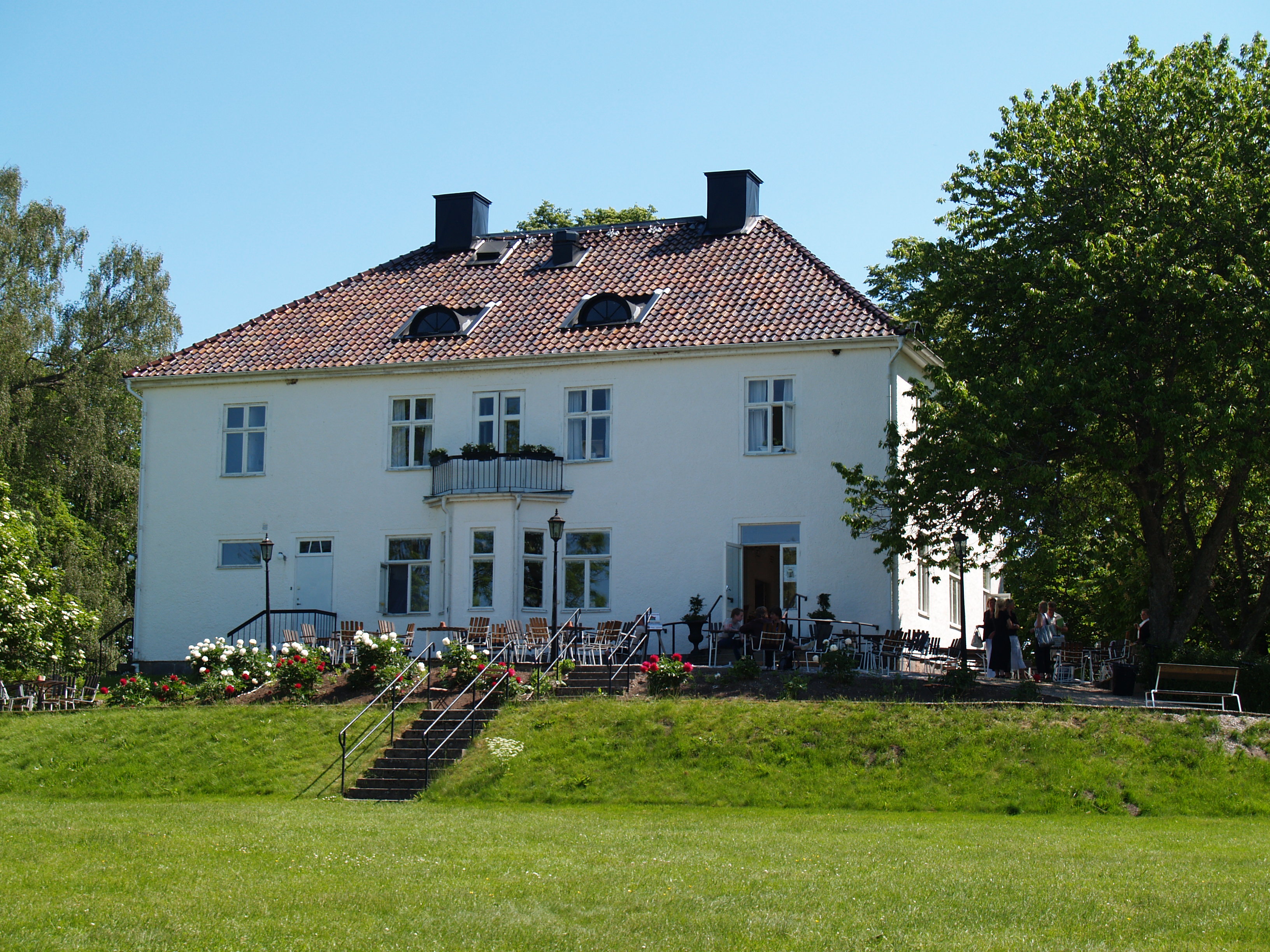 A white mansion with a grass field