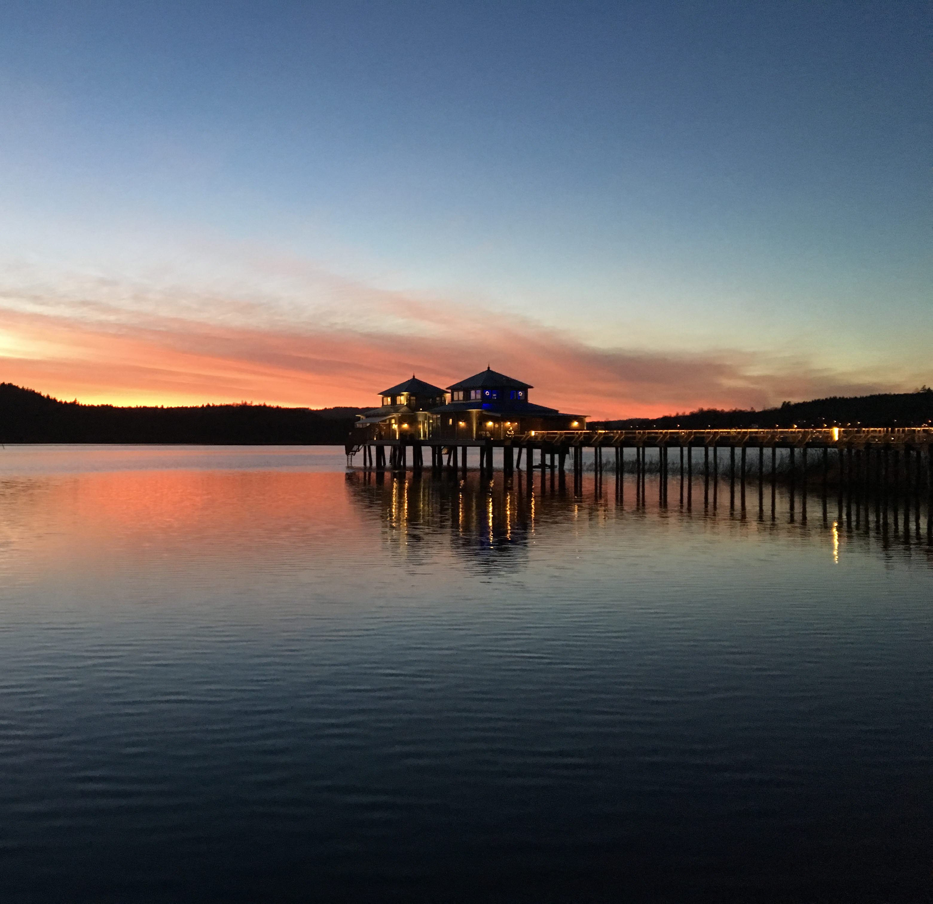 Kallbadhuset, en byggnad ute i vattnet med solnedgång i bakgrunden