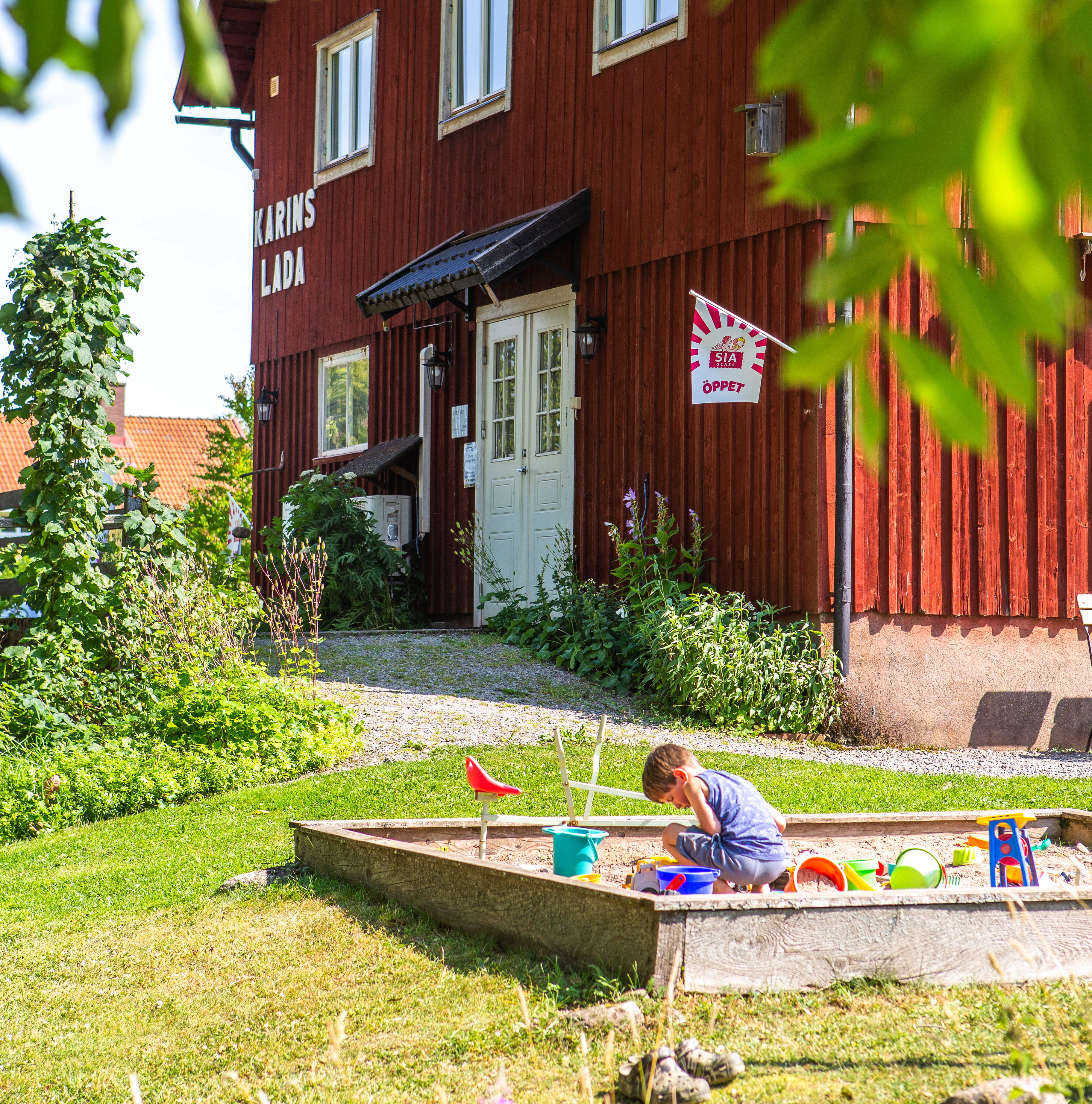 Barn som leker i sandlådan Karins Lada