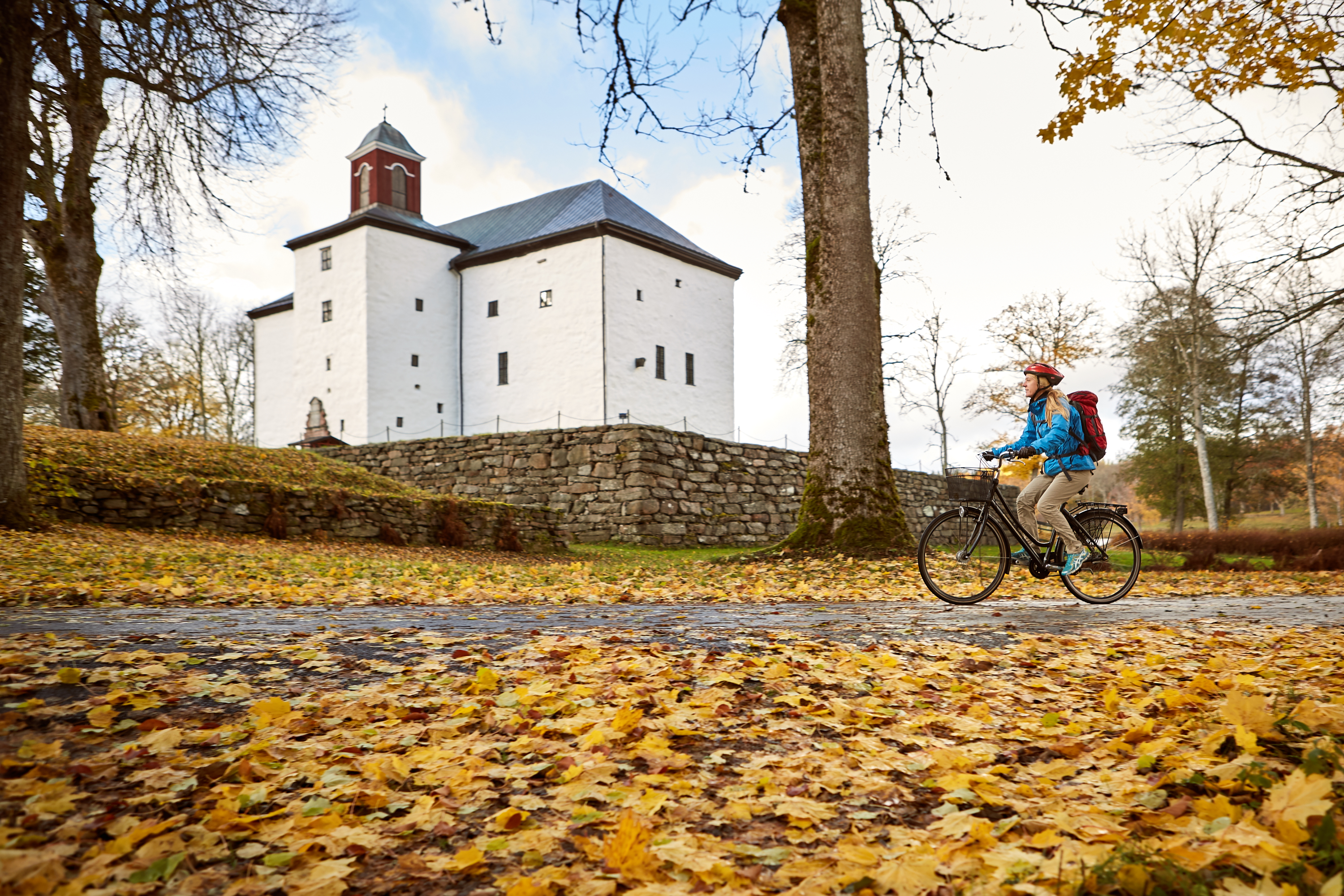 Kvinna cyklar vid Torpa Stenhus