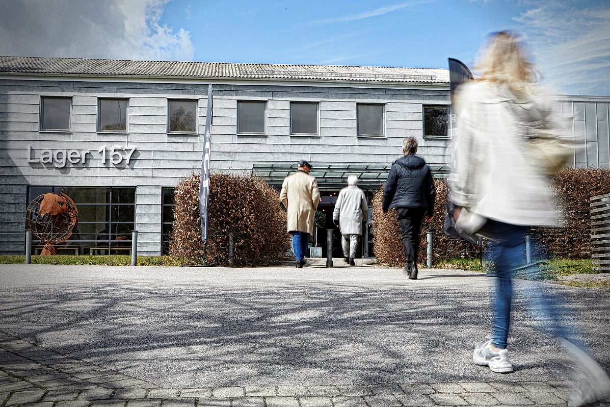 People walking towards a gray bulidning