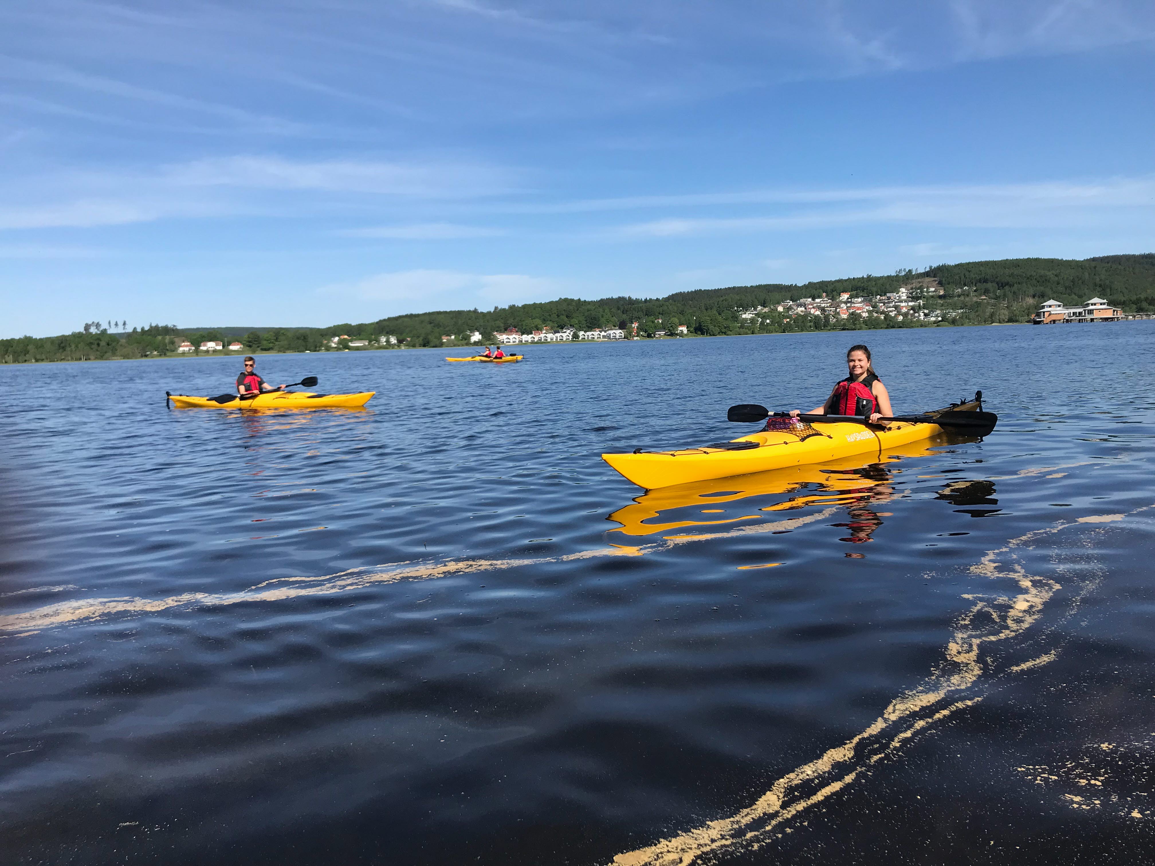Männsikor i och runt Gula kanoter på en blå sjö i Ulricehamn