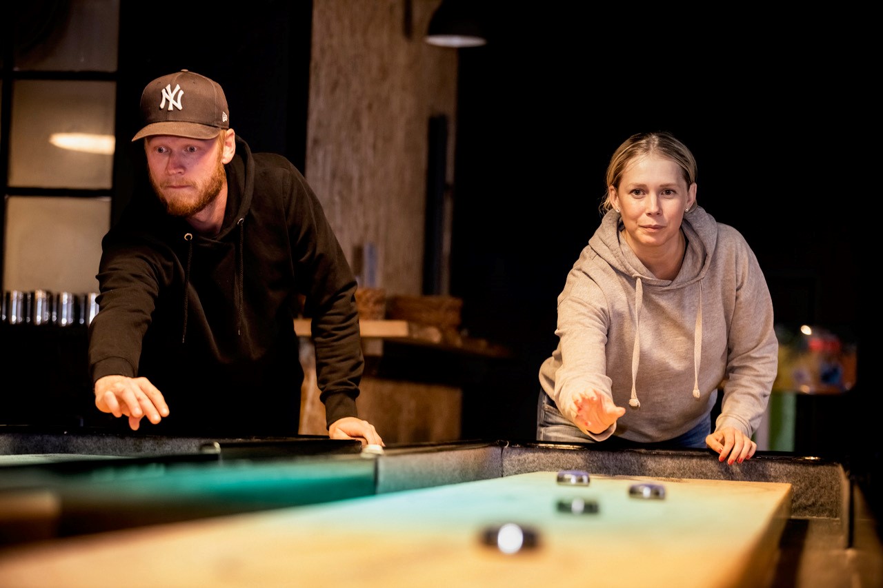 Människor som spelar shuffleboard