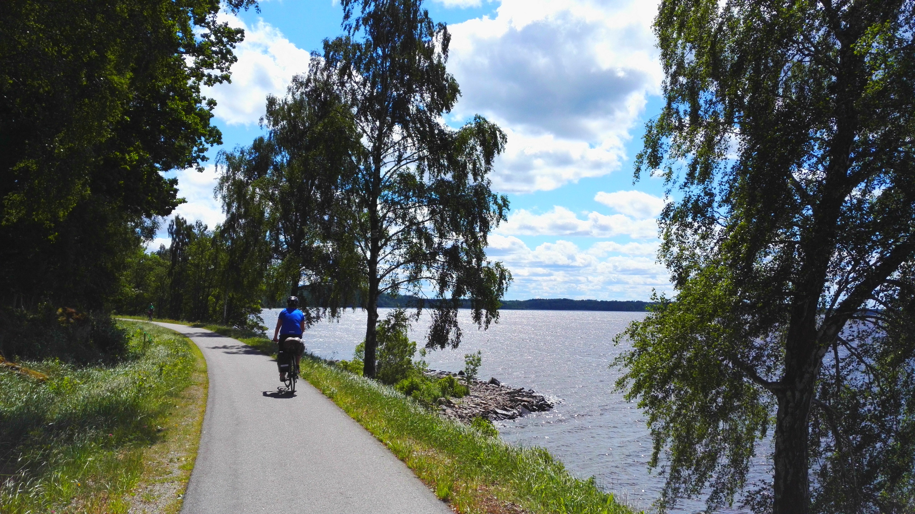 A paved patg for cucling and a lake beside it