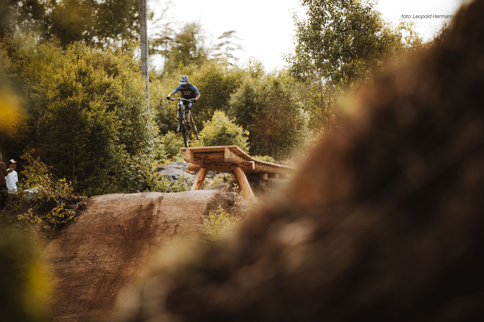 mtb åkare hoppar över gap hopp. Mtb åkaren är i luften påväg mot landning. 