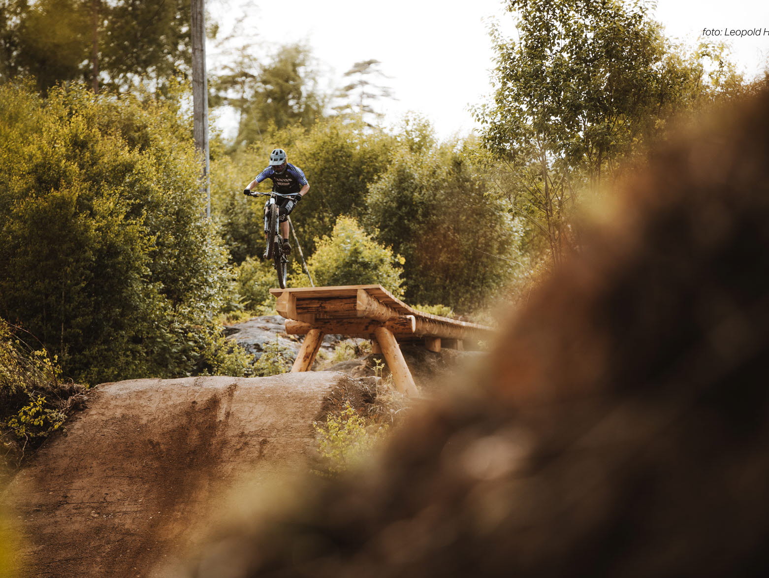 mtb åkare hoppar över gap hopp. Mtb åkaren är i luften påväg mot landning. 