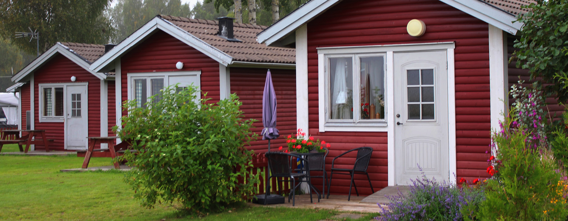 en röd stuga på en gräsmatta