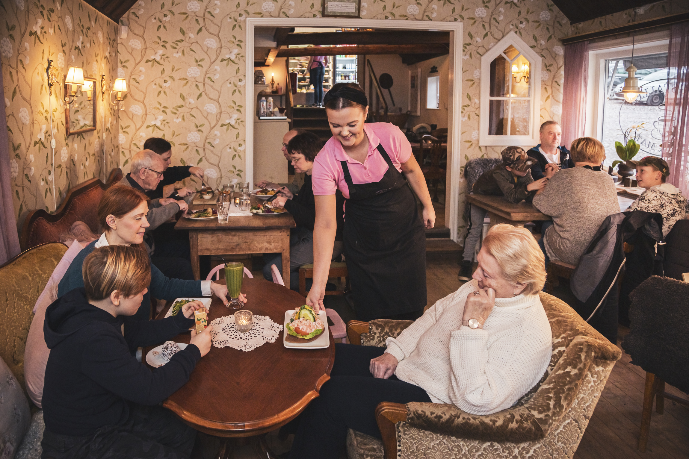 Servitris serverar en räkmacka på ett café