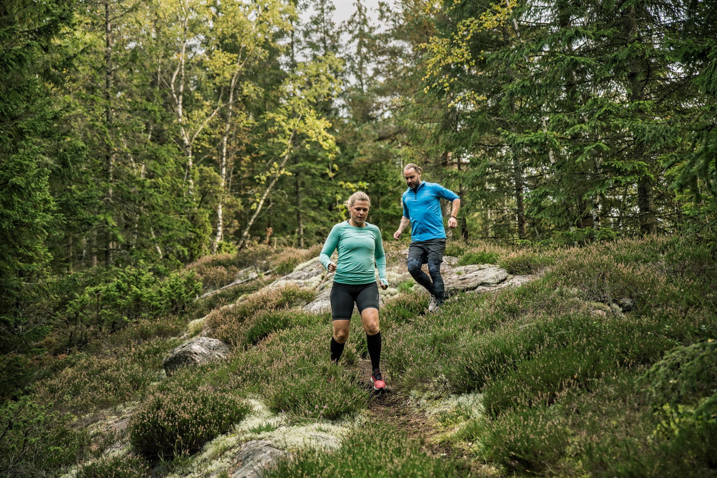 Två personer springer nedför en backe