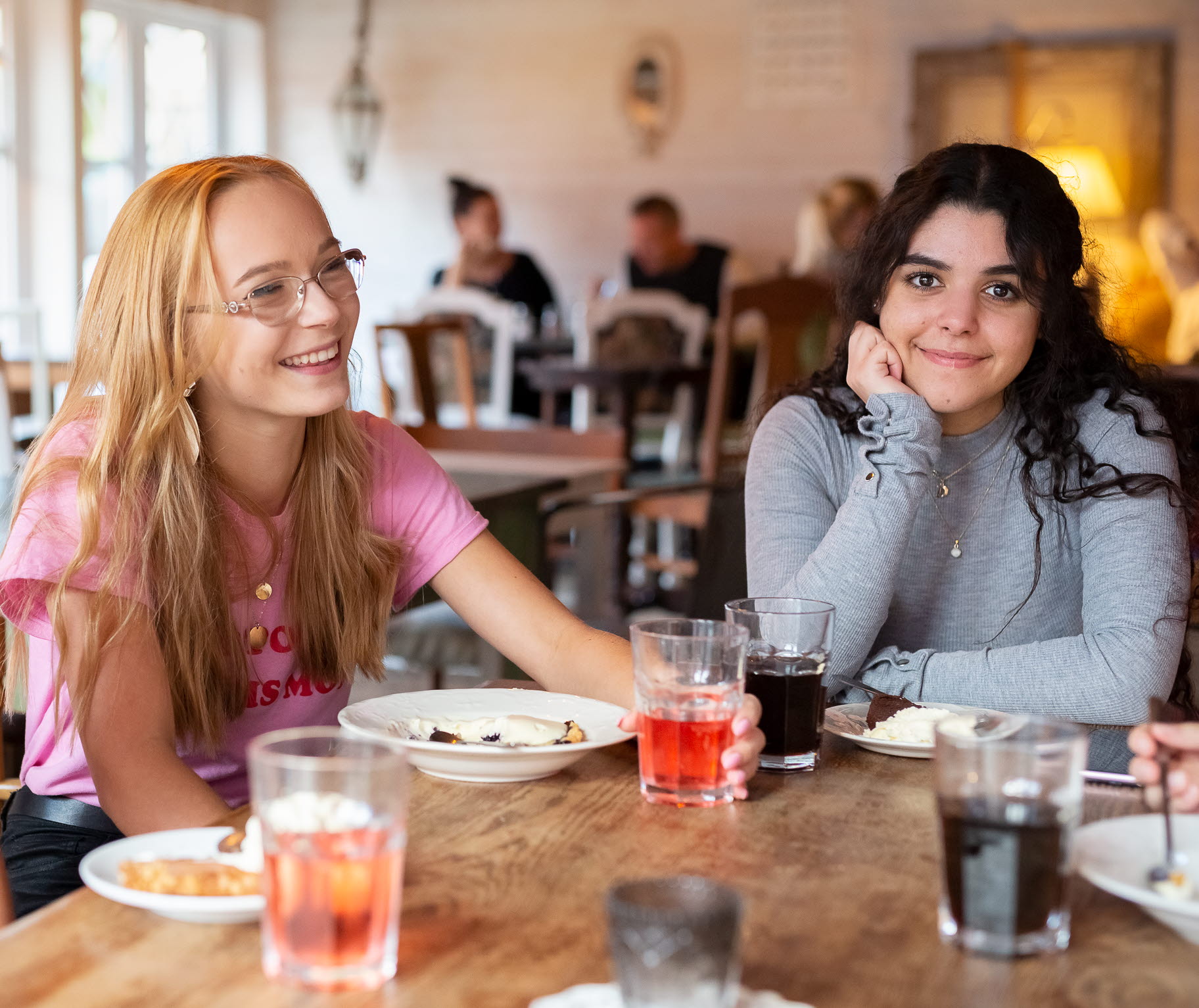 Three girls have some "fika" in Ulricehamn, one of them looks straight into the camera.