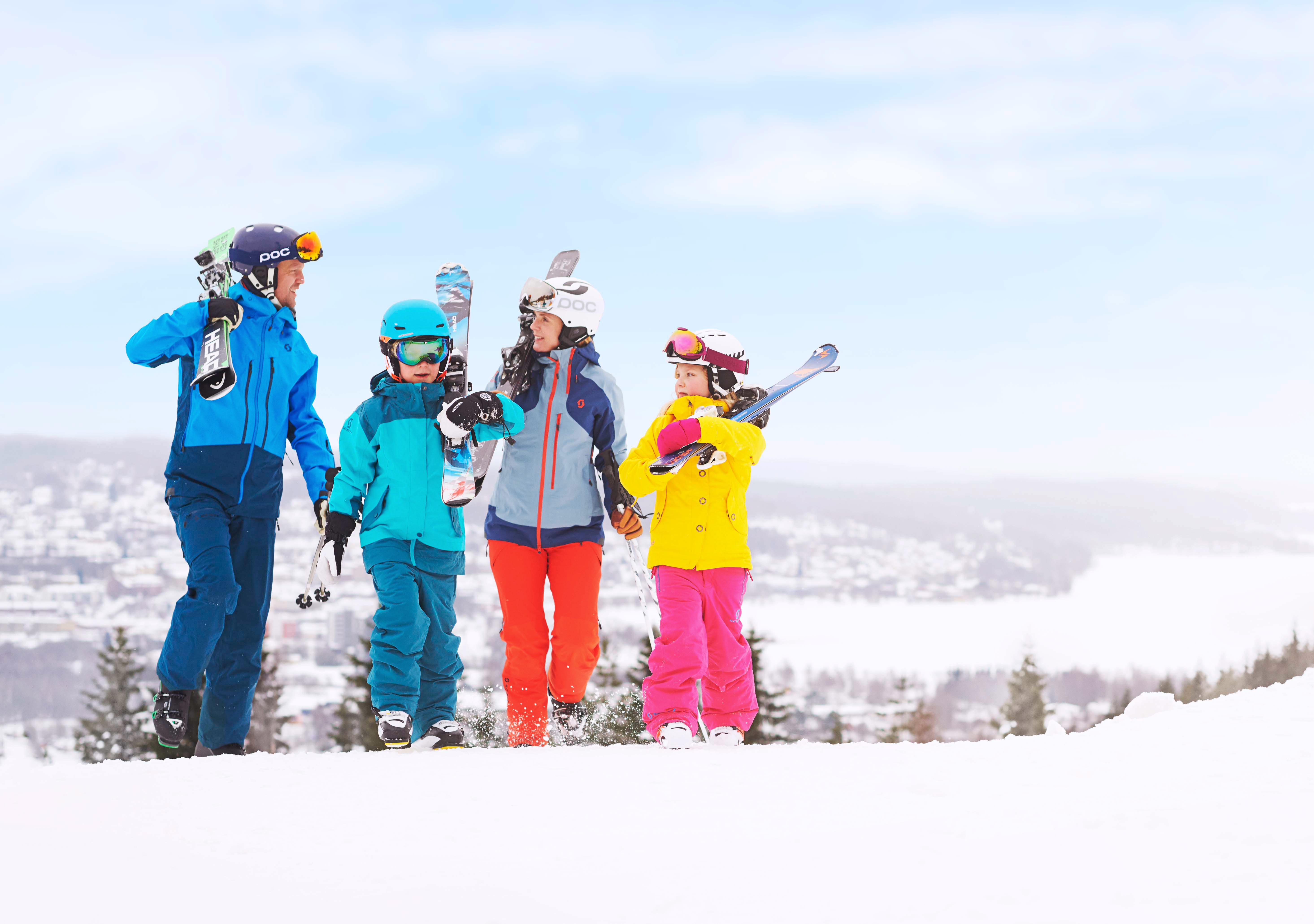 Barn och vuxna i färgglada kläder i slalombackarna i Ulricehamn