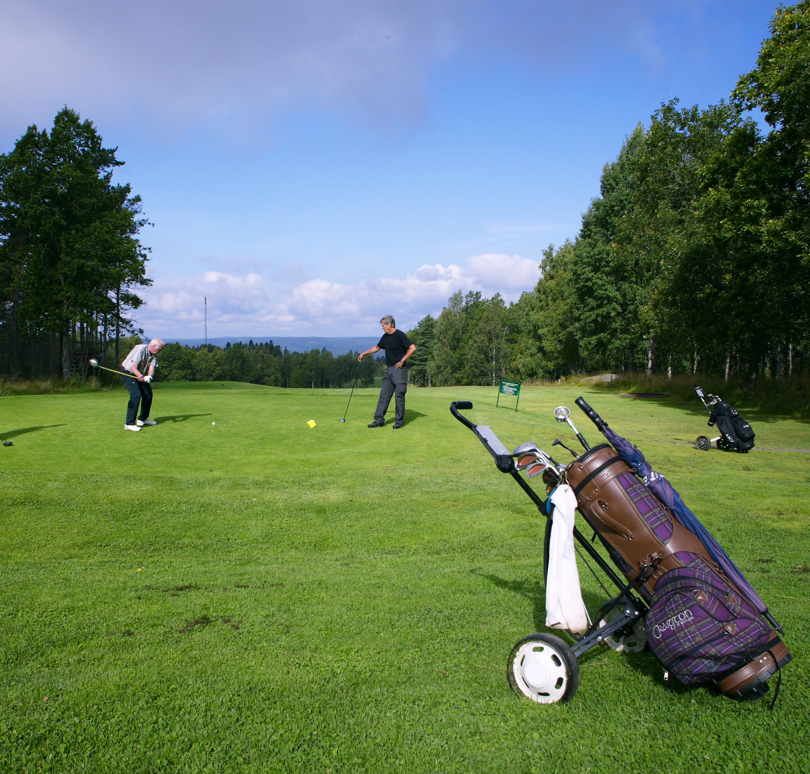 Herrar med klubban i högsta hugg på Ulricehamns Golfklubb.