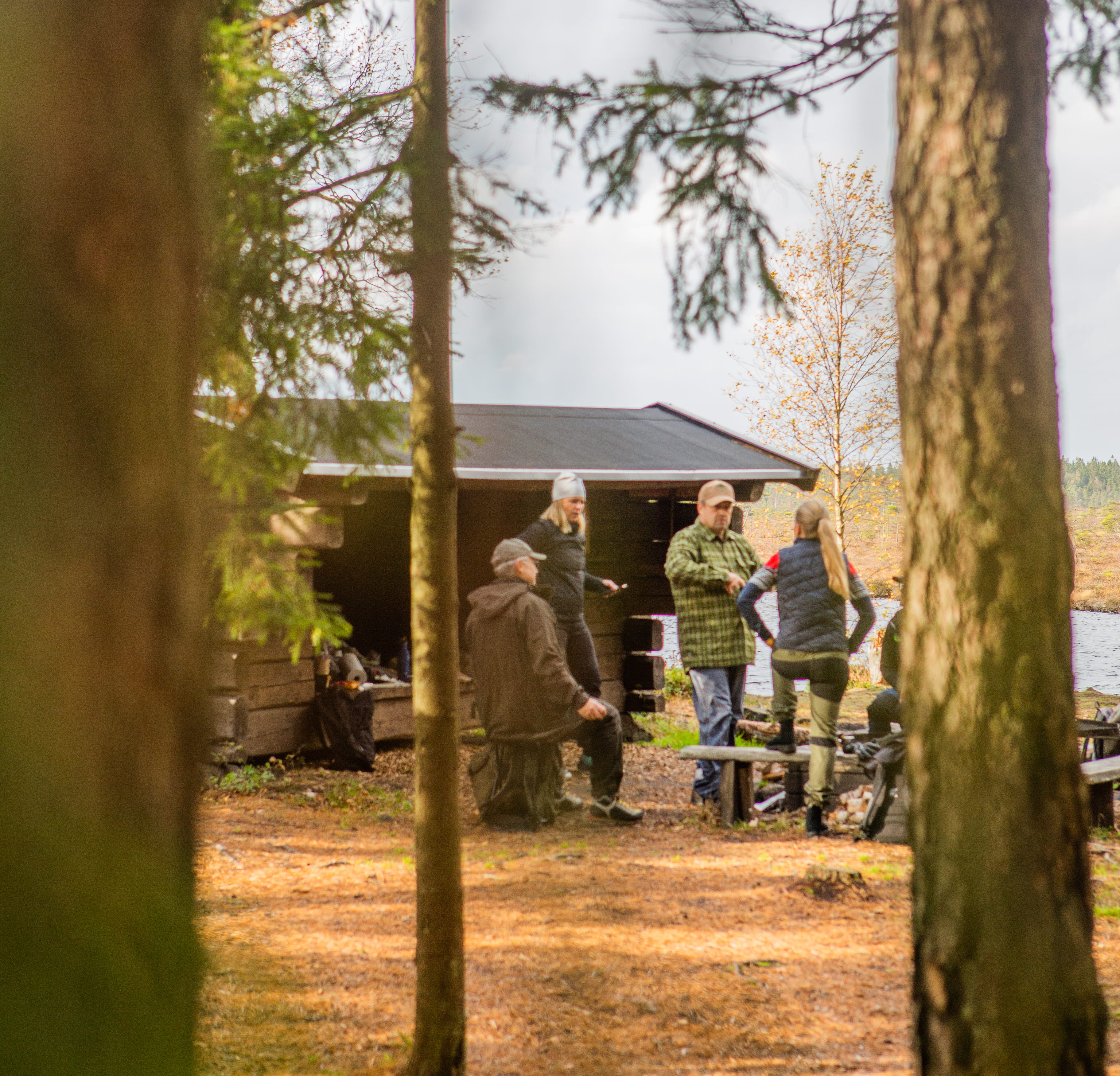 Personer vid vindskydd i skogen