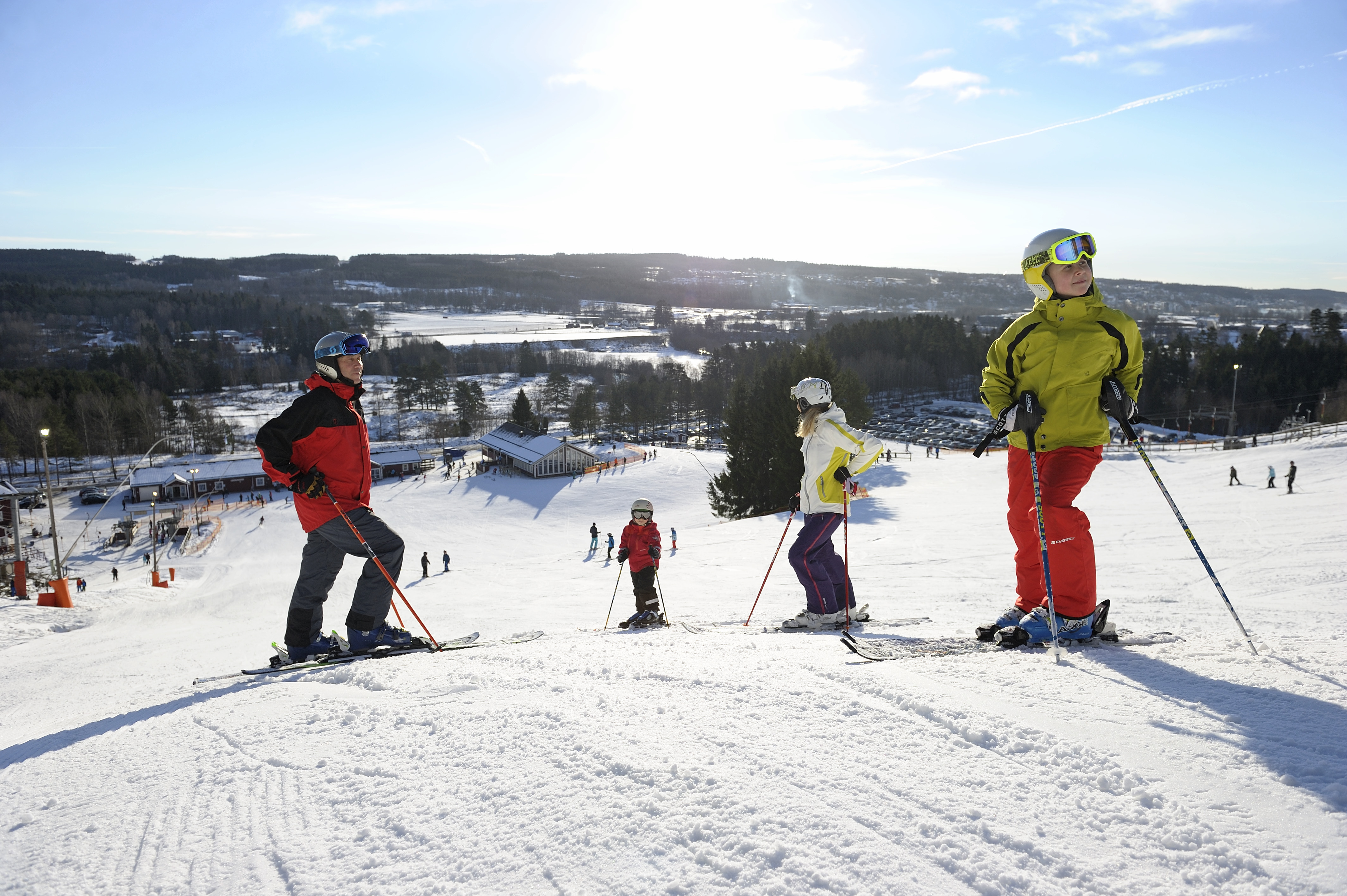 Fyra personer i färgglada skidkläder åker skidor i Ulricehamn ski center
