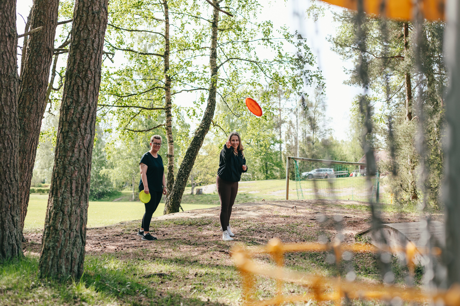 Två kvinnor som spelar discgolf. 