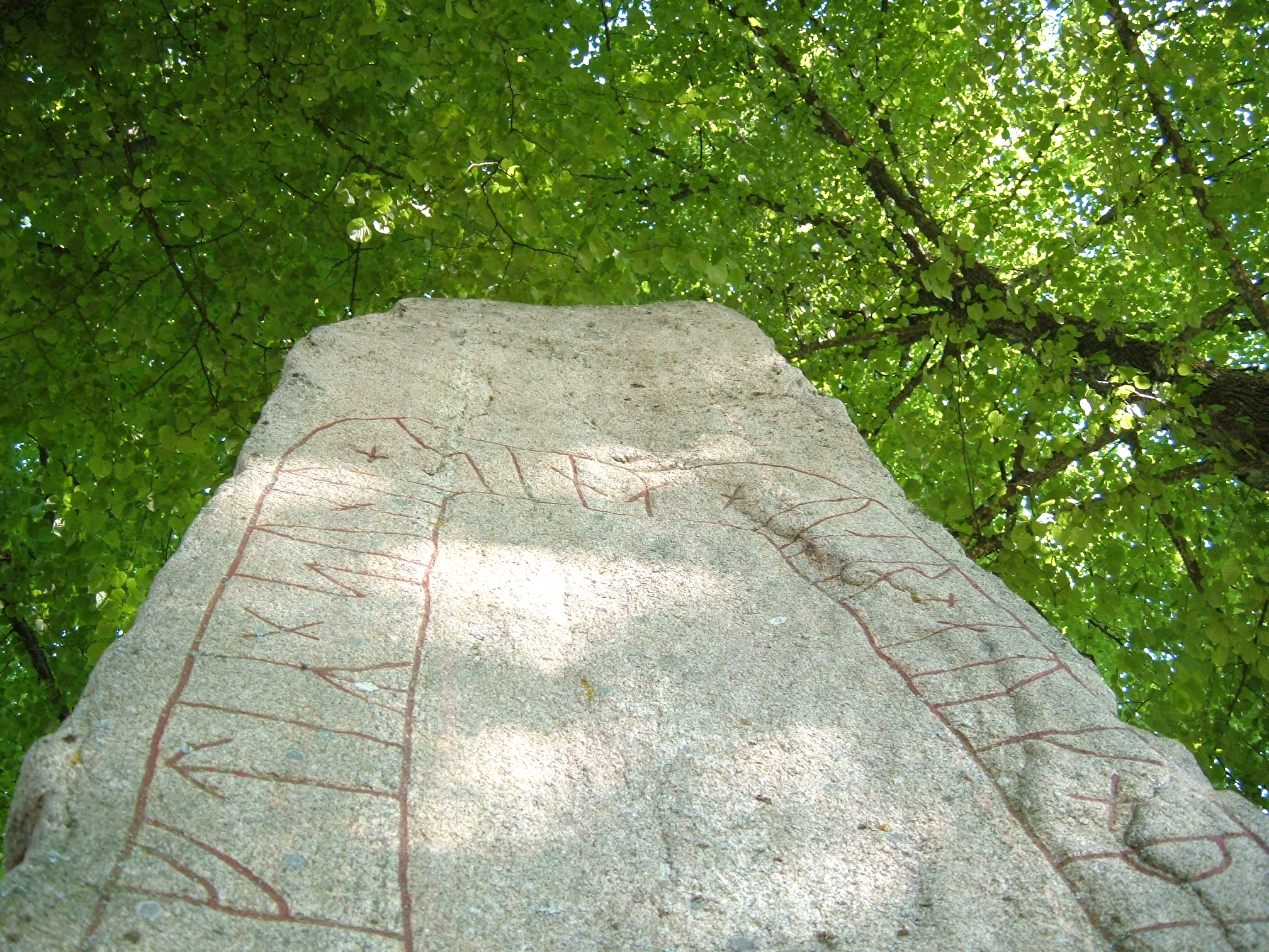 En runsten i ljusgrön omgivning.