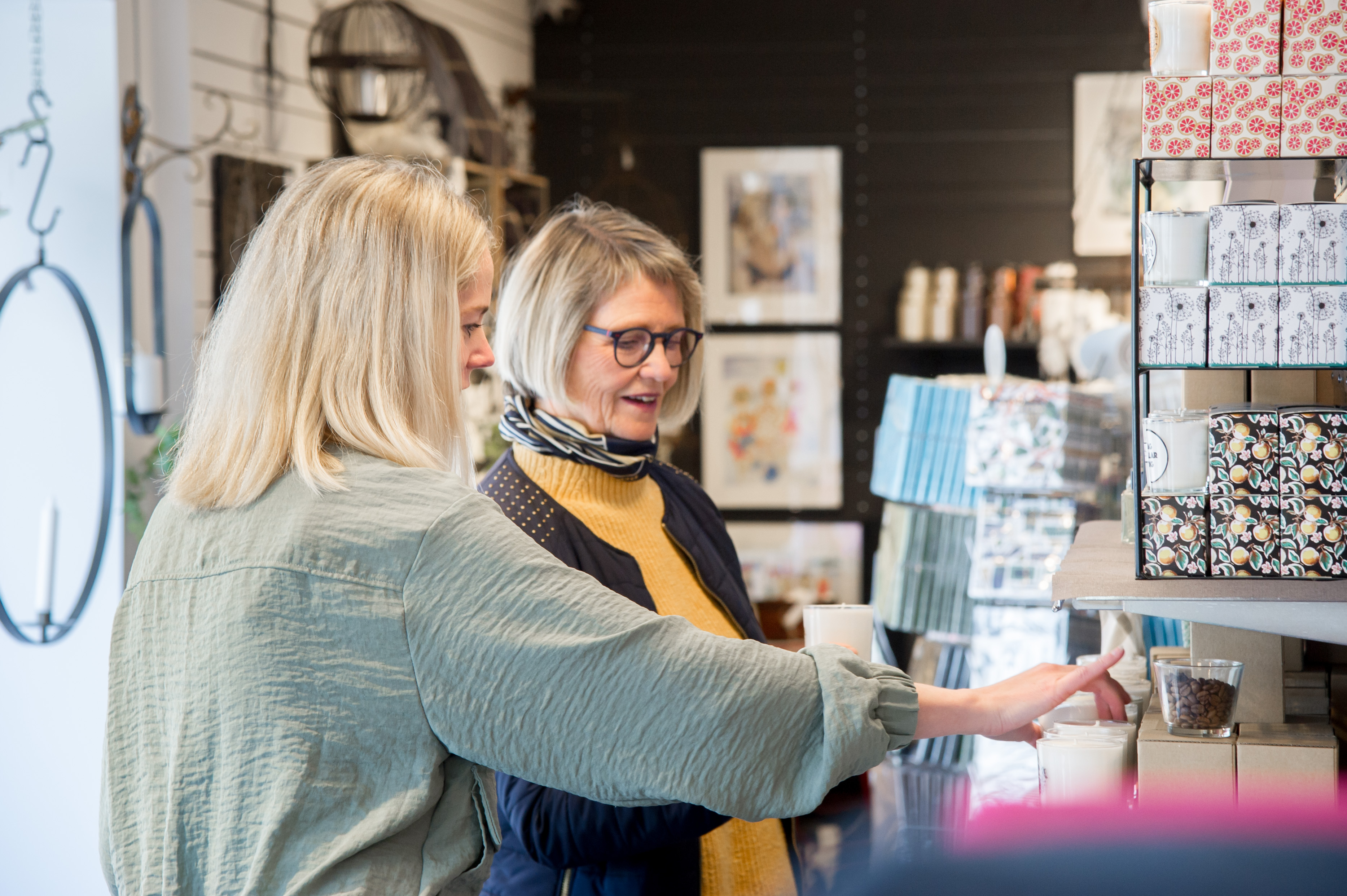 Två personer tittar på vykort inne i en butik