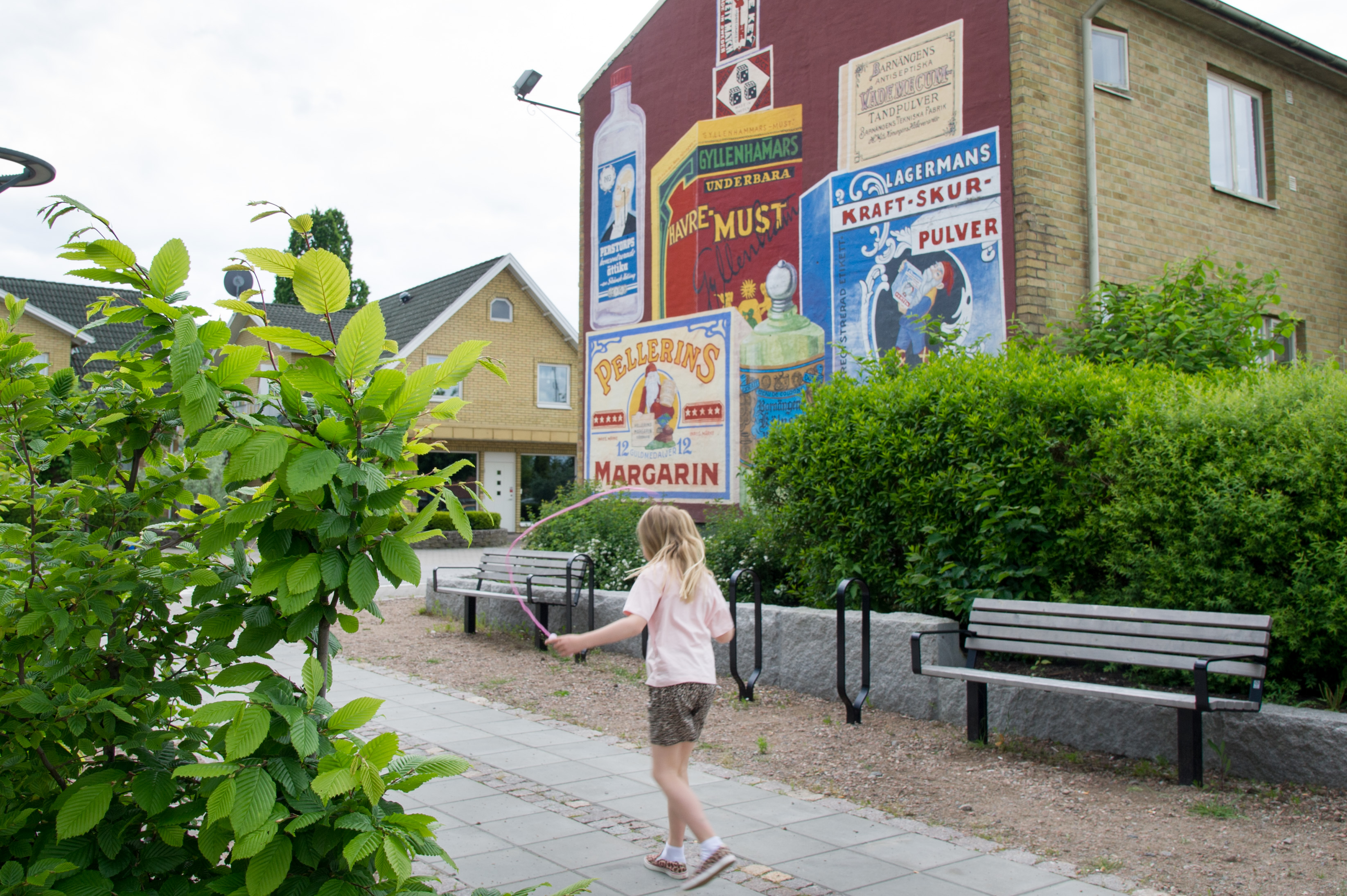 En flicka går på en gångstig vid några bänkar